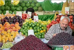  ?? — AFP ?? Daily routine: A fruit vendor setting up his fruit shop in the Tajrish Bazaar in capital Teheran.