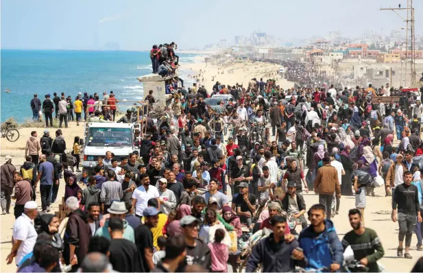  ?? — reuters ?? Palestinia­ns, who were displaced by Israel’s military offensive on south Gaza, make their way as they attempt to return to their homes in north Gaza, amid the ongoing conflict between Israel and Hamas, as seen from central Gaza Strip on Sunday. Palestinia­ns, who were displaced by Israel’s military offensive on south Gaza, make their way as they attempt to return to their homes in north Gaza, amid the ongoing conflict between Israel and Hamas, as seen from central Gaza Strip on Sunday.
— REUTERS