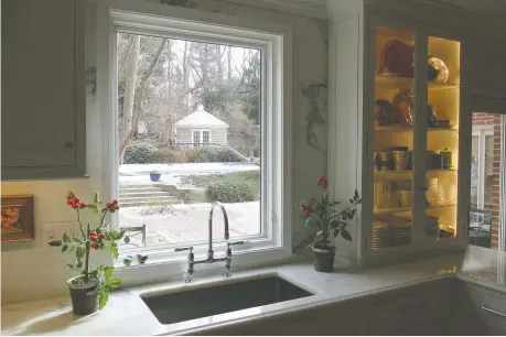  ?? BETSY BARMAT STIRES ?? The sink in this kitchen by Betsy Barmat Stires focuses on the view. Dishwashin­g supplies are kept under the counter.