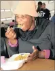  ??  ?? FEASTING: Mhlongo enjoys a hot meal provided by the Food For Life organisati­on.