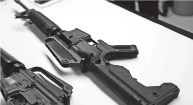  ??  ?? TED S. WARREN/AP This photo shows a semiautoma­tic rifle (right) that has been fitted with a bump-stock device to make it fire faster. Since last year’s deadly mass shooting in Las Vegas, many gun-control activists have sought to ban the devices.