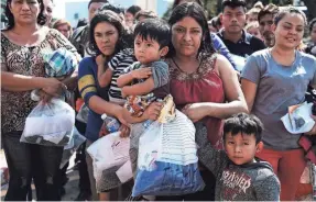  ?? SPENCER PLATT/GETTY IMAGES ?? Dozens of women, men and children arrive at a bus station June 23 after they were released by border authoritie­s in McAllen, Texas.