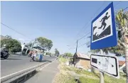  ?? EPA ?? A motorist rides past a tsunami evacuation route sign at Deah Baro Village, Banda Aceh, Indonesia, yesterday.