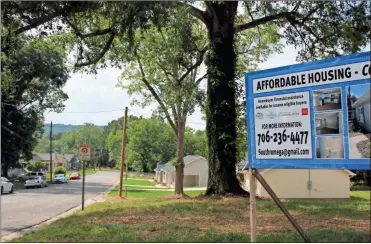  ?? Diane Wagner ?? Three of the four affordable homes built on Pollock Street are shown Wednesday on the right side of the street leading down to a former industrial site on the Coosa River slated for redevelopm­ent as public green space.