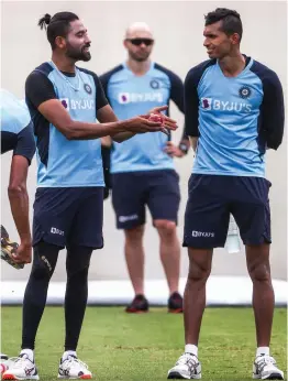  ??  ?? Indian pacer Mohammed Siraj ( left) talks to a teammate Navdeep Saini during a training session at the Sydney Cricket Ground on Tuesday, ahead of their third Test against Australia.