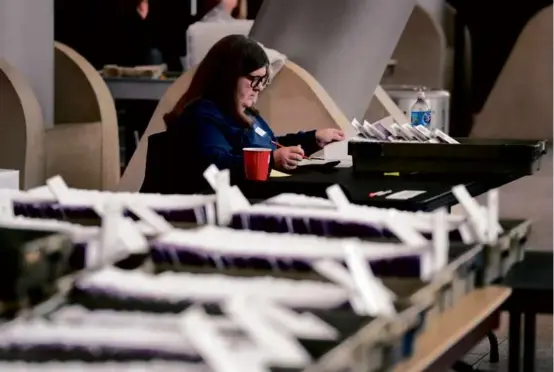  ?? CARLOS OSORIO/ASSOCIATED PRESS ?? An election worker sorted through absentee ballots Tuesday in Warren, Mich. More than 1.2 million were issued to voters.