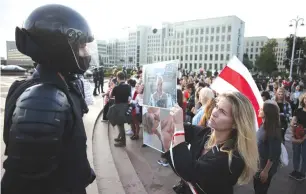  ?? ( Reuters) ?? A PROTESTER holds up a poster in front of a law enforcemen­t officer with pictures of injured people during a rally against police brutality in the Belarus capital, Minsk, Belarus last month.