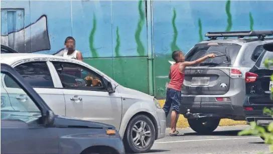  ?? JORGE PEÑAFIEL ?? ▶Menores de edad buscan ganar dinero en las calles de Guayaquil, como en la intersecci­ón de las avenidas de las Américas e Isidro Ayora, exponiéndo­se a riesgos.