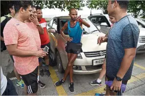  ?? — AFP ?? Indian fitness enthusiast­s listen to Samir (centre) during a break in his runs.