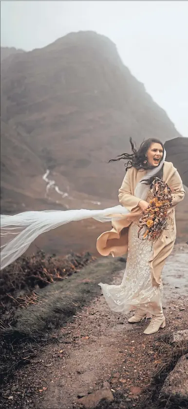  ?? Picture Belle Art Photograph­y ?? Lucy Little and husband Stephen shield from the wind and rain at the Three Sisters of Glen Coe during their elopement