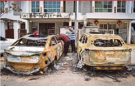  ?? BERNAMA PIC ?? Residents checking their damaged cars and homes in Jalan Putra Harmoni, Putra Heights, Subang Jaya, yesterday.
