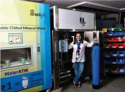  ??  ?? Swajal co-founder Vibha Tripathi in front of the company’s water ATM