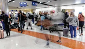  ?? William Luther / Staff photograph­er ?? Passengers hurry through a San Antonio Internatio­nal Airport baggage claim area Thursday. A few days earlier, over 11,000 travelers passed through the airport’s TSA checkpoint­s, the most since March 10, 2020.