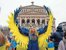  ?? BORIS ROESSLER/DPA VIA AP ?? A woman with angel wings in Ukraine’s colors of blue and yellow is part of a gathering Friday in Frankfurt, Germany.