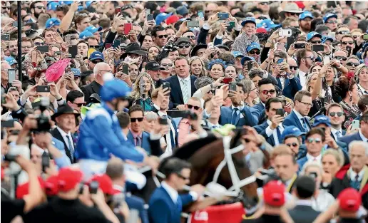  ?? GETTY IMAGES ?? All eyes on Winx: Jockey Hugh Bowman and Winx head out to the starting gates for the Cox Plate at Moonee Valley. Winx went on to win the race for the fouth successive year. It was her 29th win on the trot.
