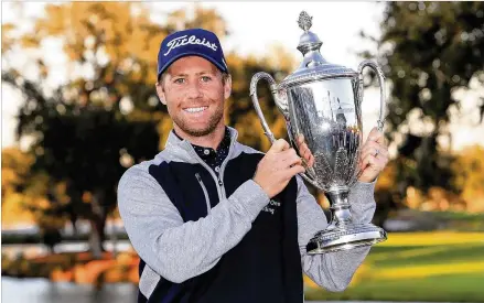  ?? STREETER LECKA / GETTY IMAGES ?? Tyler Duncan hoists the winner’s trophy after the final round of the RSM Classic on the Seaside course at Sea Island Golf Club last month in St. Simons Island. The size of the Masters field could swell to 89 players going into the new year.