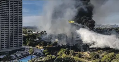  ?? Photos: David Revenga ?? A plane drops water on the fire