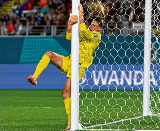  ?? ANDREW CORNAGA/ASSOCIATED PRESS ?? US goalkeeper Alyssa Naeher collides with the post, which would later come to her rescue, the woodwork denying a lastminute chance for Portugal.