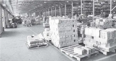  ?? IAN ALLEN/PHOTOGRAPH­ER ?? An employee checks off stock inside the new Sam Mahfood Distributi­on Centre launched by Wisynco Group on Friday, September 13, 2017.