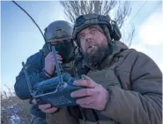  ?? AP PHOTO/EVGENIY MALOLETKA ?? A Ukrainian serviceman, right, and commander of a unit look Monday at the screen of a drone’s remote control during frontline fighting in Donetsk region, Ukraine.