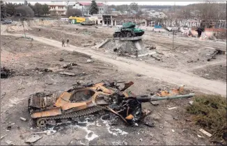  ?? Efrem Lukatsky / Associated Press ?? Residents pass a damaged Russian tank in the town of Trostsyane­ts, some 250 miles east of capital Kyiv, Ukraine, on Monday.