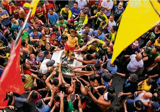  ?? —CHRIS QUINTANA/CONTRIBUTO­R ?? Devotees reach out to touch the image of Saint Sebastian while it is being returned to the Lumban Church in Laguna province after a fluvial procession.