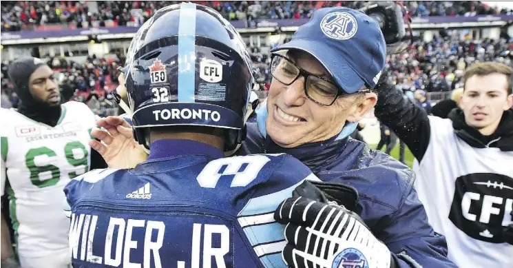  ?? FRANK GUNN/THE CANADIAN PRESS ?? The Argos’ James Wilder Jr. is hugged by head coach Marc Trestman after Toronto’s win over the Saskatchew­an Roughrider­s in Sunday’s East Division final.