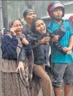  ??  ?? People react (left) as the body of a relative is retrieved from the rubble of a building in Mamuju, West Sulawesi; residents inspect (right) damaged buildings in Mamuju.