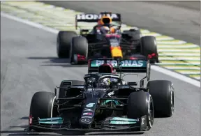  ?? ANDRE PENNER — THE ASSOCIATED PRESS ?? Mercedes’ Lewis Hamilton, front, steers his car followed by Red Bull’s Max Verstappen , during the Brazilian Formula One Grand Prix at the Interlagos race track in Sao Paulo, Brazil, Sunday, Nov. 14, 2021.