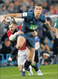  ?? Picture: AFP ?? HANGING ON: The Auckland Blues’ Matt Duffie is tackled close to the side line by British and Irish Lions’ Elliot Daly during their match at Eden Park in Auckland