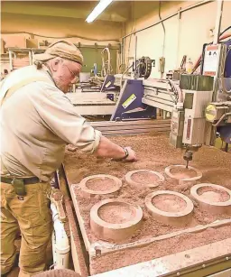  ?? PHOTOS BY GLENN RUSSELL/BURLINGTON FREE PRESS ?? Randy Ouellette clears sawdust away as an automated router shapes blocks of wood at Vermont Butcher Block &amp; Board Company in Williston, Vt., in July 2017.