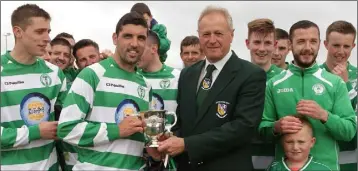  ??  ?? James Carty of Shamrock Rovers receiving the silverware from Denis Hennessy (League Chairman).