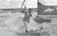  ??  ?? A man digging up sand