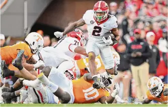  ?? Eakin Howard/getty Images ?? Georgia’s Kendall Milton runs the ball against Tennessee in the second quarter Saturday at Neyland Stadium. The Bulldogs romped after falling behind 7-0.