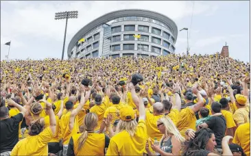  ?? PHOTOS BY CHARLIE NEIBERGALL / ASSOCIATED PRESS ?? The crowd inside Iowa’s Kinnick Stadium waves to pediatric patients in the 12-story Stead Family Children’s Hospital across the street. “The Wave” has beome a national sensation.