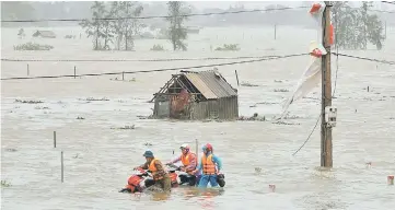  ??  ?? People recover motorbikes from a flooded fields while the Doksuri storm hits in Ha Tinh province, Vietnam. — Reuters photo