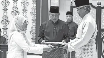  ??  ?? Sultan Abdullah (right) presenting the instrument of appointmen­t to Tengku Maimon at Istana Negara yesterday. Bernama photo