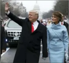  ?? EVAN VUCCI — THE ASSOCIATED PRESS FILE ?? President Donald Trump waves as he walks with first lady Melania Trump during the inaugurati­on parade on Pennsylvan­ia Avenue in Washington.