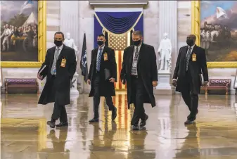  ?? J. Scott Applewhite / Associated Press ?? Security officials survey the Capitol in advance of the Jan. 20 presidenti­al inaugurati­on of Joe Biden. The violent siege last week has heightened concerns of unrest in Washington.