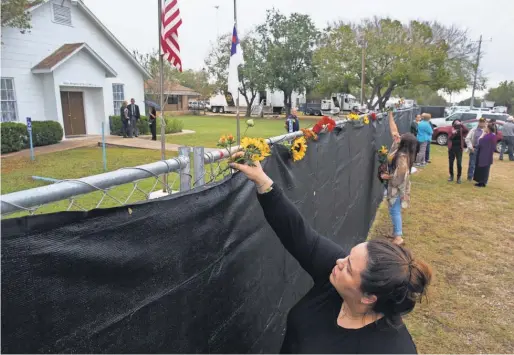  ?? COURTNEY SACCO/ CALLER- TIMES ?? Rachel Vasquez places flowers outside First Baptist Church in Sutherland Springs, Texas, as worshipers gathered in a large tent in an athletics field Sunday for the church’s first service since last week’s deadly shooting.