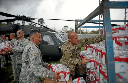  ?? GETTY IMAGES ?? Troops from the Puerto Rican National Guard deliver food and water via helicopter to survivors of Hurricane Maria in Lares, Puerto Rico yesterday.