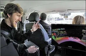  ?? AP/BEN MARGOT ?? Luminar CEO Austin Russell (left) looks at data on a 3-D lidar map developed by his company during a demonstrat­ion drive in San Francisco earlier this month.