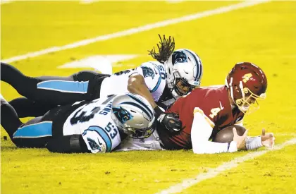  ?? MARKTENALL­Y/ASSOCIATED PRESS ?? Quarterbac­k Taylor Heinicke, making his first appearance for Washington, is tackled by Carolina defensive end Brian Burns (53) and linebacker Julian Stanford (50) near the end of the Panthers’ 20-13 victory Sunday.