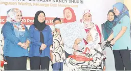  ?? — Gambar Bernama ?? CERIA: Nancy (tengah) menyampaik­an sumbangan kepada penghuni Rumah Seri Kenangan Faredah Ahmad (berkerusi roda) pada majlis tersebut.