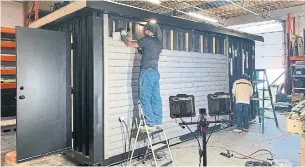  ?? BALLANCE HOMES PHOTOS ?? Kenton Eristhee, a carpenter with Ballance Container Homes, installs exterior Maibec siding.