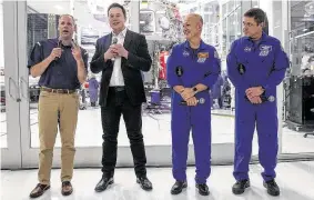  ?? Brian van der Brug / Los Angeles Times ?? SpaceX CEO Elon Musk, second from left, and others talk with reporters in front of the clean room where the Dragon Crew capsule is assembled in California.