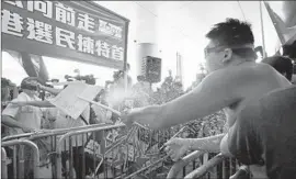  ?? Kin Cheung
Associated Press ?? AN ADVOCATE of the pro-Beijing election framework sprays water at a prodemocra­cy demonstrat­or, right, outside the Legislativ­e Council in Hong Kong.