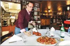  ?? AP ?? Frank Pellegrino Jr, co-owner of Rao’s, serves the restaurant’s signature meatballs at the 120-year-old eatery by a park in East Harlem, New York.