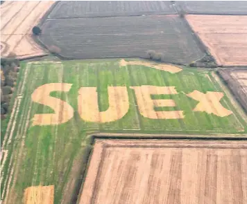  ??  ?? Murray Graham, pictured with son George and wife Sue, left, created the message in the field as a romantic gesture for his wife