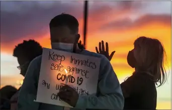  ?? STEVE GRIFFIN — THE DESERET NEWS VIA AP, FILE ?? In this Oct. 13, 2020, file photo, family members of inmates incarcerat­ed in the Utah Department of Correction­s’ prison system hold candles and say a prayer following a rally outside the Department of Correction­s office in Draper, Utah.